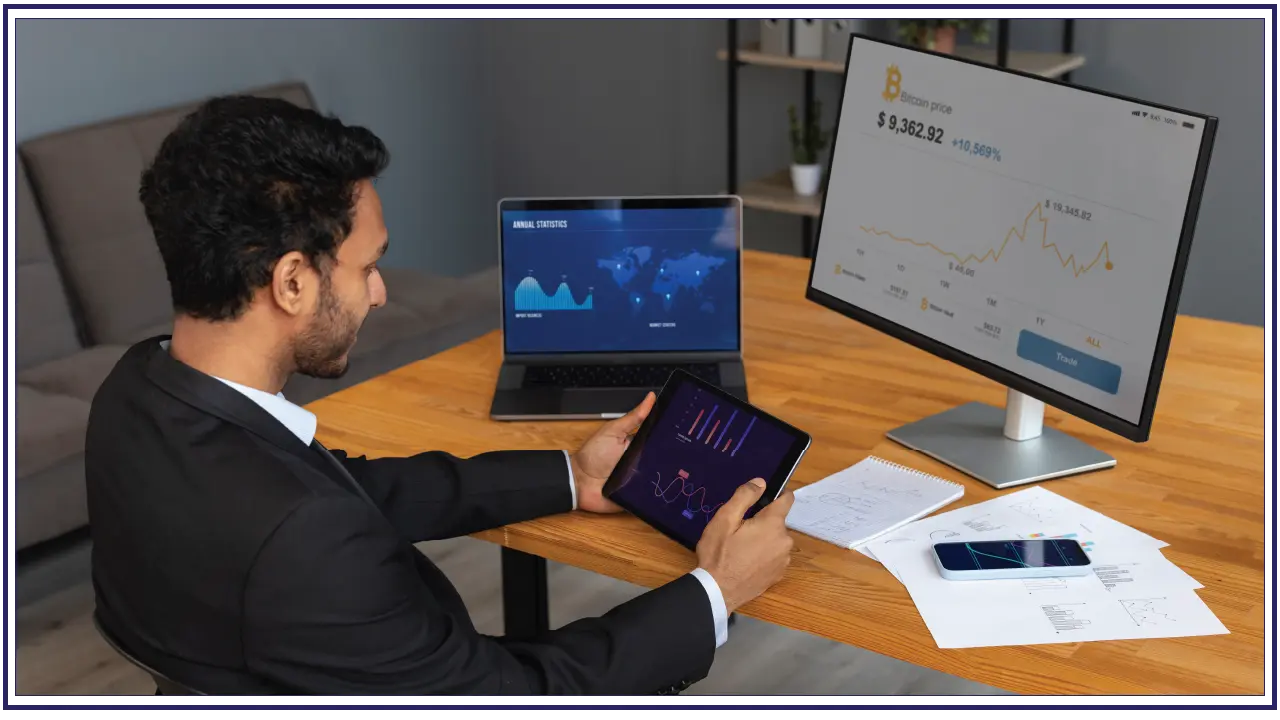 Man using an ipad and a laptop - how to register a company in bahrain